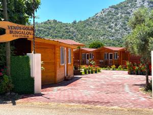 a sign in front of a row of wooden cabins at Venüs Gold Bungalov Adrasan in Kumluca