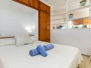 a white bed with two blue pillows on it at Apartment Arernal by Interhome in Hospitalet de l'Infant