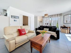 a living room with a couch and a table at Holiday Home Les Embruns by Interhome in La Bernerie-en-Retz