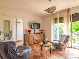 a living room with two chairs and a tv at Holiday Home Maison du Pountet by Interhome in Lacapelle-Biron