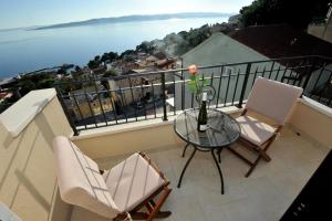 a balcony with two chairs and a glass table at Villa Tomislav 2 in Brela