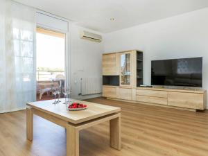 a living room with a table and a flat screen tv at Holiday Home Refuge de la Mer by Interhome in Cunit
