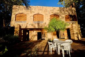 Una mesa y sillas frente a un edificio. en Nile View House, en Asuán