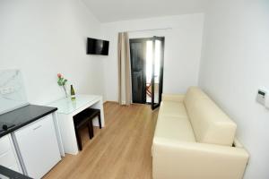 a white living room with a white couch and a desk at Villa Tomislav 2 in Brela