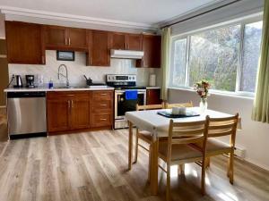 a kitchen with wooden cabinets and a table with chairs at Urban Retreat in Nanaimo