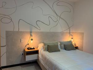 a bedroom with a bed with a large painting on the wall at Departamento Sol Urbano in Rafaela