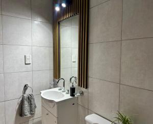 a bathroom with a sink and a mirror at Departamento Sol Urbano in Rafaela +5 photos