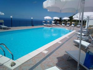 a swimming pool with chairs and umbrellas at Agriturismo La Palombara in Paola