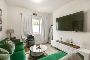 a living room with a green couch and a flat screen tv at Golden Hill Gem 2 Mi to Gaslamp Quarter - Dogs OK! in San Diego