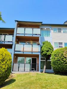 an apartment building with balconies and a yard at 1 bedroom in 3 BR condo in Tukwila +11 photos