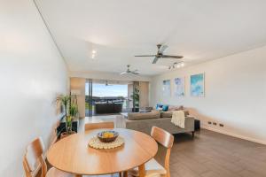 a living room with a table and a couch at Delightful Waterfront Lagoon Views & Restaurants in Darwin