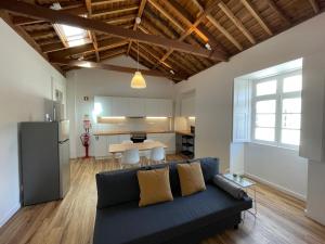 a living room with a couch and a kitchen at Casa da Arquitectura - Texturas in Angra do Heroísmo