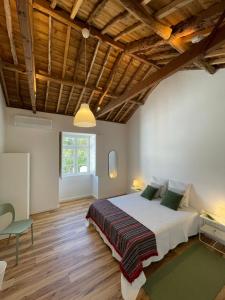a bedroom with a large bed and wooden ceilings at Casa da Arquitectura - Texturas in Angra do Heroísmo