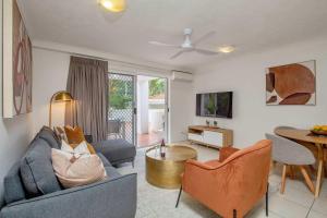ゴールドコーストにあるSpacious Ground Floor Retreat by Burleigh Beachのソファと椅子とテーブルのあるリビングルーム