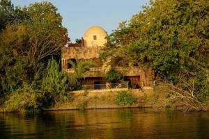 un edificio en una colina junto a un cuerpo de agua en Nile View House, en Asuán