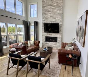 a living room with leather furniture and a brick wall at The Lamp House in Nordegg