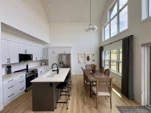 a kitchen with white cabinets and a table and chairs at The Lamp House in Nordegg