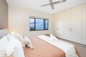 a bedroom with a large bed with a window at Picturesque Waterfront Lagoon Views Top Lvl & BBQ in Darwin +7 photos