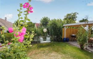 un giardino con panchina e fiori rosa di Charming Home In Samsø With 1 Bedroom a Brundby Altre 31 foto