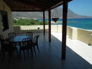 a patio with a table and chairs and the ocean at Gramvoussa Bay in Kissamos
