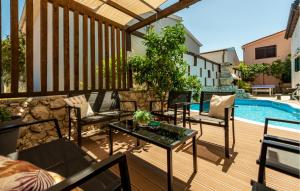 leżak z krzesłami i stół przy basenie w obiekcie Four-Bedroom Holiday Home In Vir w mieście Vir