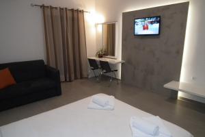 a living room with a couch and a tv on a wall at Gramvoussa Bay in Kissamos