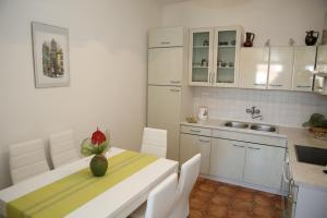 a kitchen with a table with a vase on it at Apartments Vila&Zora in Vodice +30 photos