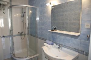 a blue tiled bathroom with a sink and a shower at Apartments Vila&Zora in Vodice