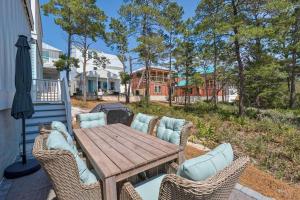 a wooden table and chairs on a patio at The Hideaway in Santa Rosa Beach