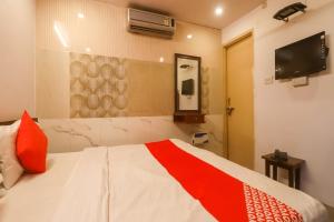 ein Schlafzimmer mit einem Bett mit einer rot-weißen Decke in der Unterkunft Super Hotel O Maa Arya in Lucknow + 18 Fotos