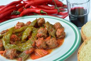 a plate of food with meatballs and peppers on a table at Gastronomy Hotel Kritsa in Portaria