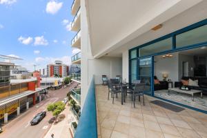 a balcony with a table and chairs on a building at Ideal CBD Location with Harbour Views Pool Gym & BBQ in Darwin