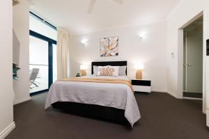 a bedroom with a large bed and a large window at Ideal CBD Location with Harbour Views Pool Gym & BBQ in Darwin