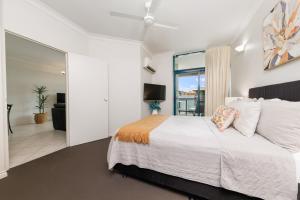 a bedroom with a large bed and a living room at Ideal CBD Location with Harbour Views Pool Gym & BBQ in Darwin +9 photos