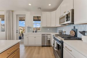 eine Küche mit weißen Schränken und einem Herd mit Backofen in der Unterkunft Surfside Escape condo in St. George
