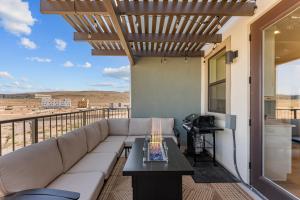 ein Wohnzimmer mit einem Sofa und einem Tisch auf dem Balkon in der Unterkunft Surfside Escape condo in St. George