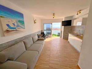 a large living room with a couch and a kitchen at Bungalow with sea view in Caleta De Fuste