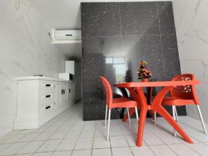 eine Küche mit einem roten Tisch und 2 Stühlen in der Unterkunft No coração da Praia do Frances in Marechal Deodoro