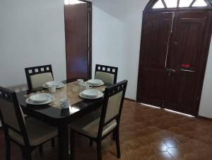 a dining room table with chairs and a black table with cups and plates at Nuevo departamento en el centro de Coatepec in Coatepec +2 photos