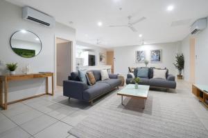 Una sala de estar con dos sofás y una mesa. en Sub-Penthouse Stunner Harbour Views & Pool, en Darwin