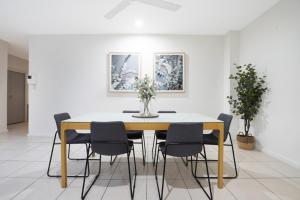 Una mesa de comedor y sillas en una habitación. en Sub-Penthouse Stunner Harbour Views & Pool, en Darwin