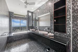 Un baño con dos lavabos y un espejo grande. en Ultimate Penthouse Majestic Harbour Views & Pool, en Darwin 10 fotos más
