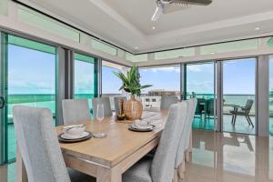 a dining room with a wooden table and chairs at Premier Penthouse Serene Harbour Views BBQ & Pool in Darwin