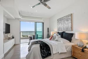a bedroom with a bed and a large window at Premier Penthouse Serene Harbour Views BBQ & Pool in Darwin +8 photos