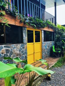 a yellow door on a building with plants at Casajungla Hostel in Jacó