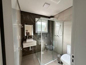 a bathroom with a shower and a toilet and a sink at Apto excelente in Canela