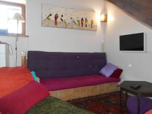 a living room with a couch and a tv at Maison charmante avec jardin, proche Val Joly, animaux admis, WiFi - FR-1-510-166 in Willies