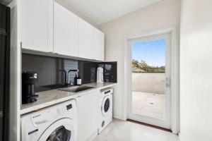 a kitchen with a washer and dryer in a room at Urunga Magic 1A in Urunga