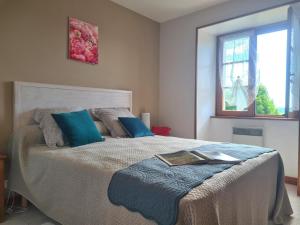 a bedroom with a large bed with blue pillows at Maison Périgourdine avec piscine, WiFi, animaux acceptés - FR-1-616-77 in Daglan +19 photos
