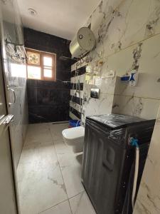 a bathroom with a toilet and a black and white tiles at Feel at Home Tranquil trails home stay naddi in Dharamshala